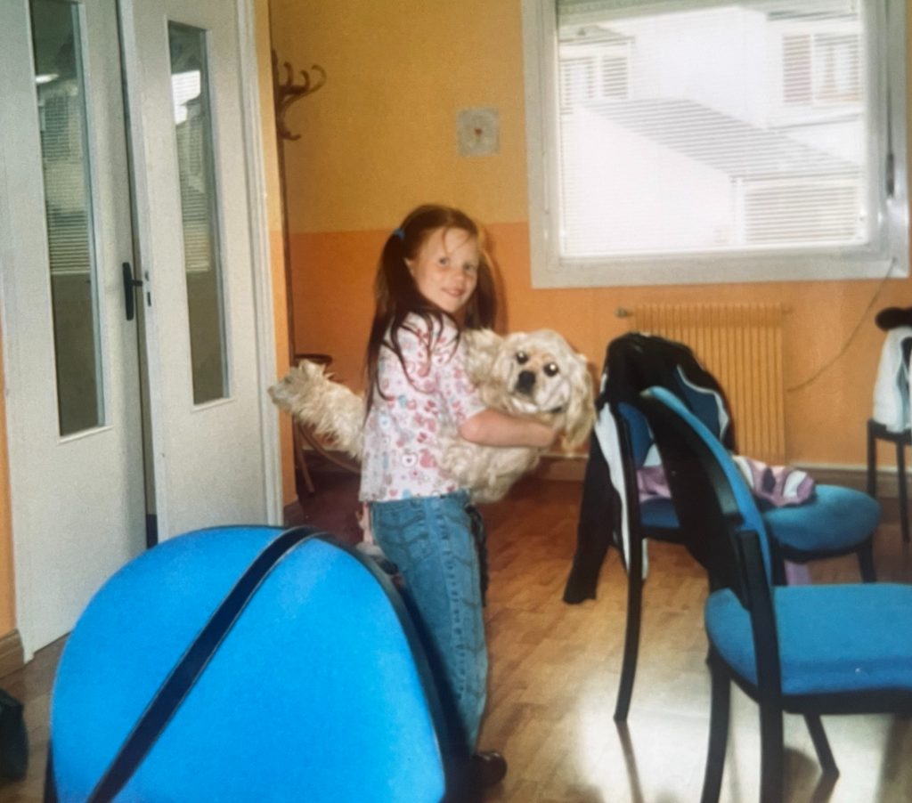 Petite fille (Mélinda Dervaux) portant son chien, cocker américain Alaska, premier chien d’enfance – inspiration du nom Amilaska pour l’entreprise